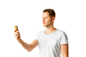 Aufkleber - A man in a white t-shirt looking at his yellow phone, isolated on a white background, symbolizing modern communication