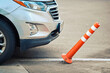 Сar hit plastic parking barrier and torn out post's fastening. Broken orange barrier, damaged parking bollard. Car knocked down parking post. Torn out delineator post in parking lot, bad driving