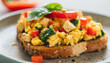 Toasted bread with tofu scramble with diced bell peppers and spinach. Tasty food. Delicious snack.