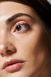 © LIGHTFIELD STUDIOS - A young caucasian woman with  clean skin is featured in a close-up, highlighting her captivating brown eyes.