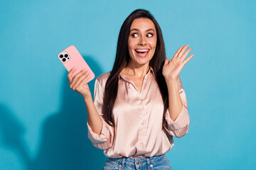 Wall Mural - Photo of excited impressed woman wear silky blouse texting sms modern gadget looking empty space isolated blue color background