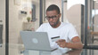 © stockbakers - African American Man Shopping Online on Laptop