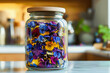 Edible flowers. Colorful pansies in glass jar, kitchen background