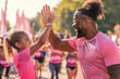 High Five for Health. In a sea of pink, a joyful father and daughter share a high five, celebrating a run, with the glow of accomplishment and familial bond on their faces