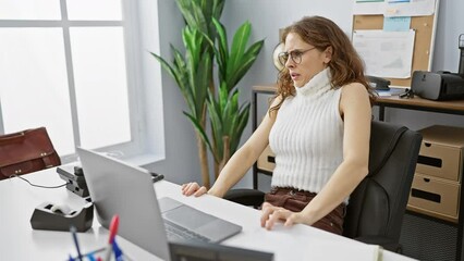 Wall Mural - Beautiful young woman in shock at the office, terrified expression, stop gesture with hands, afraid and shouting - a panic concept displaying workplace stress and fear