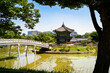 South Korea, Seoul. Gyeongbokgung palace area garden and park. Hyangwonjeong pavilion and bridge. City skyline in the background. Summer travel and tourist attraction. Beautiful Korean landscape.