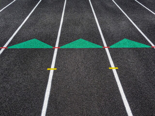 Wall Mural - Track and Field Running Lanes. Overhead view of a rubber black running track surface with white lane lines. Green arrows point forward. Rubber black surface.