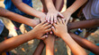 © thanakrit - Diverse group of children joining hands together in a gesture of unity and teamwork