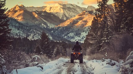 Wall Mural - Rider on ATV enjoying a snowy mountain trail at sunset