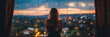 Woman stands by a window, looking out at city lights, in thought, a moment of introspection and inner exploration.