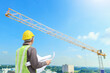 © Kwangmoozaa - construction engineer worker in protective helmet and blueprints paper on hand at building site background