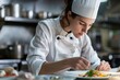 © GHArtwork - Caucasian women chef doing food plating in the kitchen