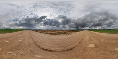 Wall Mural - hdri 360 panorama on wet gravel road among fields in spring nasty day with storm clouds in equirecta