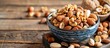 A blue bowl filled with an assortment of nuts, including almonds, placed on a wooden table.