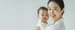 © Amonthep - Asian mom hold baby smile and kissing on baby cheek happiness moment together isolated on white background.