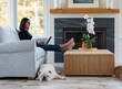 © Raymond Forbes LLC/Stocksy - Woman on laptop computer at home with family pet bulldog resting