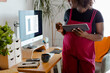 © Jimena Roquero/Stocksy - Crop of Pregnant woman in home office checking tablet device