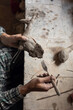 © Demetr White/Stocksy - man sculpting a tail on a bird