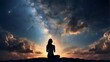 silhouette of a woman in prayer set against a gorgeous cloudscape and starry night sky. Worship