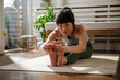 © Jovo Jovanovic/Stocksy - Asian woman stretching arms and legs on yoga mat