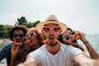 © Lucas Ottone/Stocksy - Young people at the beach taking a funny selfie eating