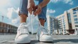 Closeup woman in stylish white sneakers tying shoelaces in city building background. AI generated