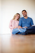 © peopleimages.com - Happy couple, portrait and sitting on living room floor in new house for memories, drinks and home renovation. Dreaming, apartment and decision for decoration, interior design and future planning.