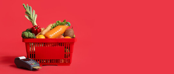 Poster - Shopping basket full of food with payment terminal and credit card on red background