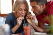 © peopleimages.com - Happy couple, juice and sharing in house with drink, enjoy and color straw for fun together. Love, milkshake and happiness of man with woman in home for romantic relationship, dating and glass