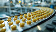 Automated pharmaceutical production line producing yellow pills in blister. The manufacturing process of medical pills on a conveyor belt. Pharmaceutical industry concept.