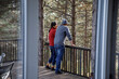 © Jovo Jovanovic/Stocksy - Couple talking in balcony seen through window at log cabin