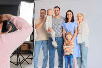 Wall Mural - Male photographer taking picture of big family in studio