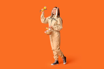 Sticker - Happy female beekeeper in bunny ears with Easter basket and tools on orange background