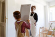 © Jimena Roquero/Stocksy - Kid helping his mother moving boxes in new home
