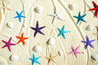 Colored starfish and shells on white fine sand.