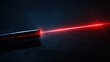 Red laser beam emanating from metallic cylindrical device on dark surface
