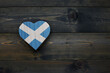 wooden heart with national flag of scotland on the wooden background.