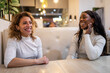 © Lupe Rodríguez/Stocksy - multiracial friends enjoying conversation in a restaurant at night
