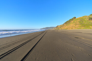 Wall Mural - Deserted sand beach at sunset during windy summer day on pacific ocean (Iloca, Chile)