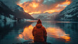 A person in an orange jacket sits on a rock by a lake. AI.
