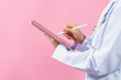 Close up hands of medical doctor using tablet pc isolated on pink background.