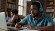 Concentrated African American male student in glasses and wireless headset studying handwriting in notebook, focused biracial man worker in headphones make notes watching webinar or training on laptop
