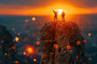 The silhouette of two hiker climbers stands on the peak, celebrating the success achieved by working as a team to achieve goals, against the backdrop of an orange sunset.