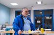 © Raul Navarro/Stocksy - doctor with stethoscope holding a tray of food in a hospital