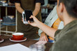 © Jovo Jovanovic/Stocksy - Professional making online payment through smart phone at cafe