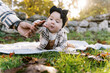 © Serena Burroughs/Stocksy - happy little baby outdoors in autumn on a blanket