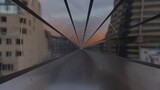 Fototapeta Na ścianę - A glass sky train between high building in a sunset time (3D Rendering)