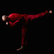 Male in red costume practicing qigong in the dark
