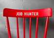 Red chair back with text written JOB HUNTER- concept of person in job hunting or seeking employment - looking for a job