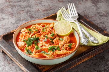 Wall Mural - Traditional mexican crockpot chicken tomato salsa close-up in a bowl on a wooden board. Horizontal